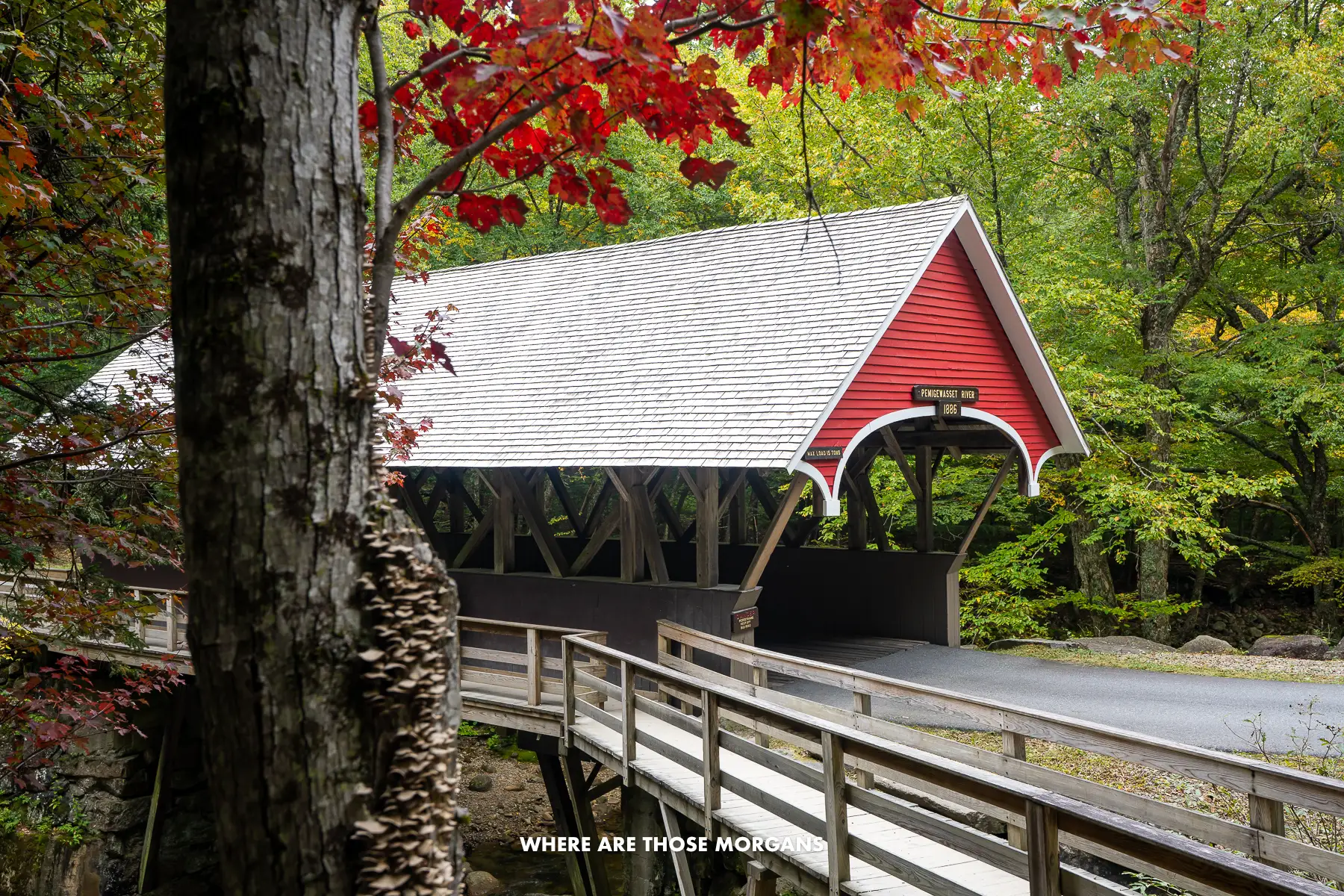 The Historic Flume Covered Bridge in Flume Gorge with green and red leaves in the fall
