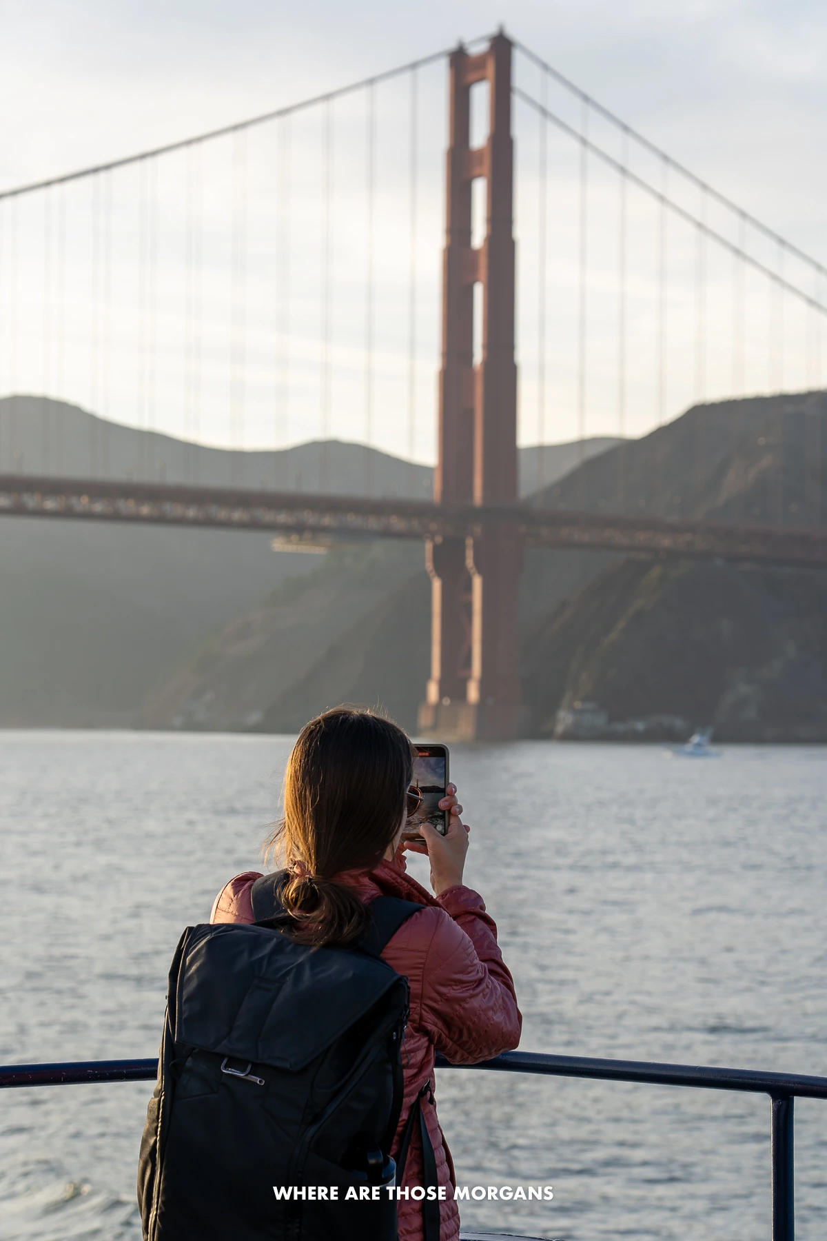 Kristen from Where Are Those Morgans taking photos and videos on a phone from a boat cruise in San Francisco Bay