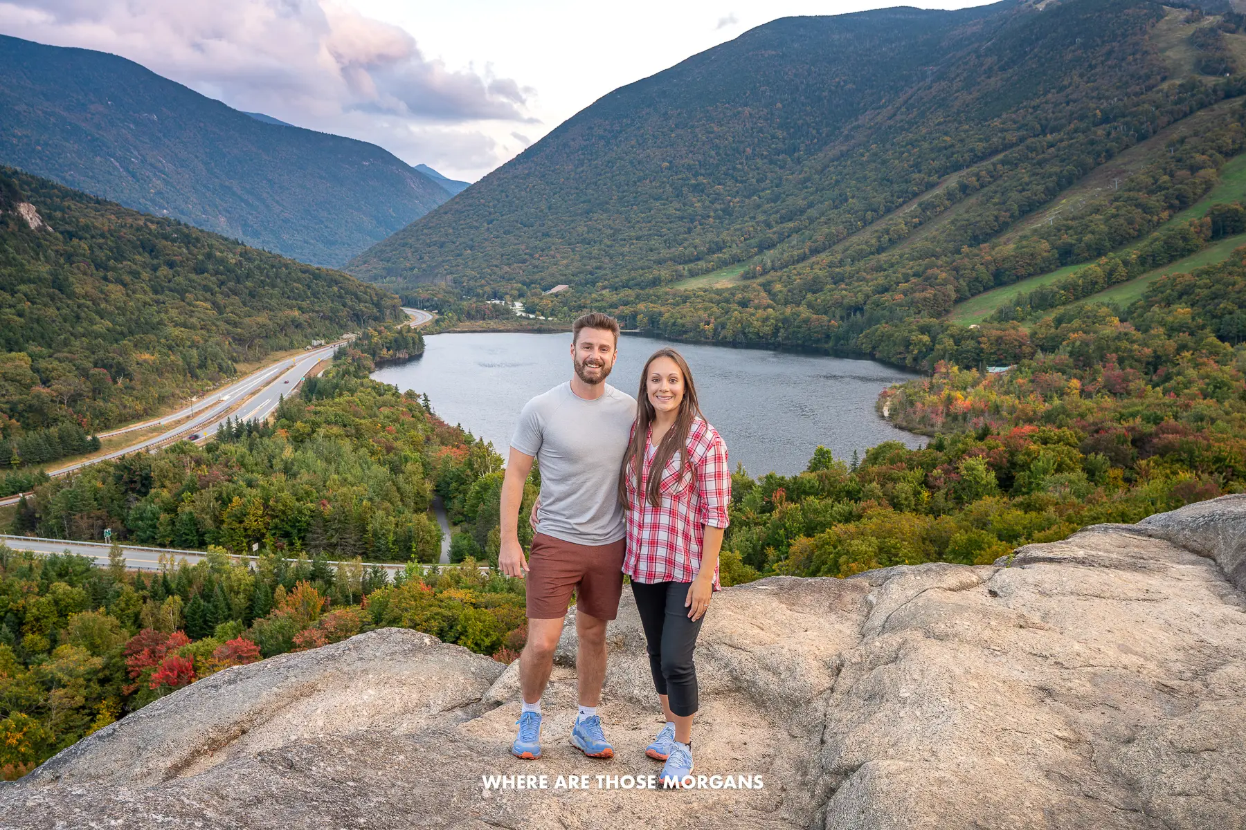 Mark and Kristen from Where Are Those Morgans having a photo taken together at Artists Bluff summit in New Hampshire, USA at sunset in fall