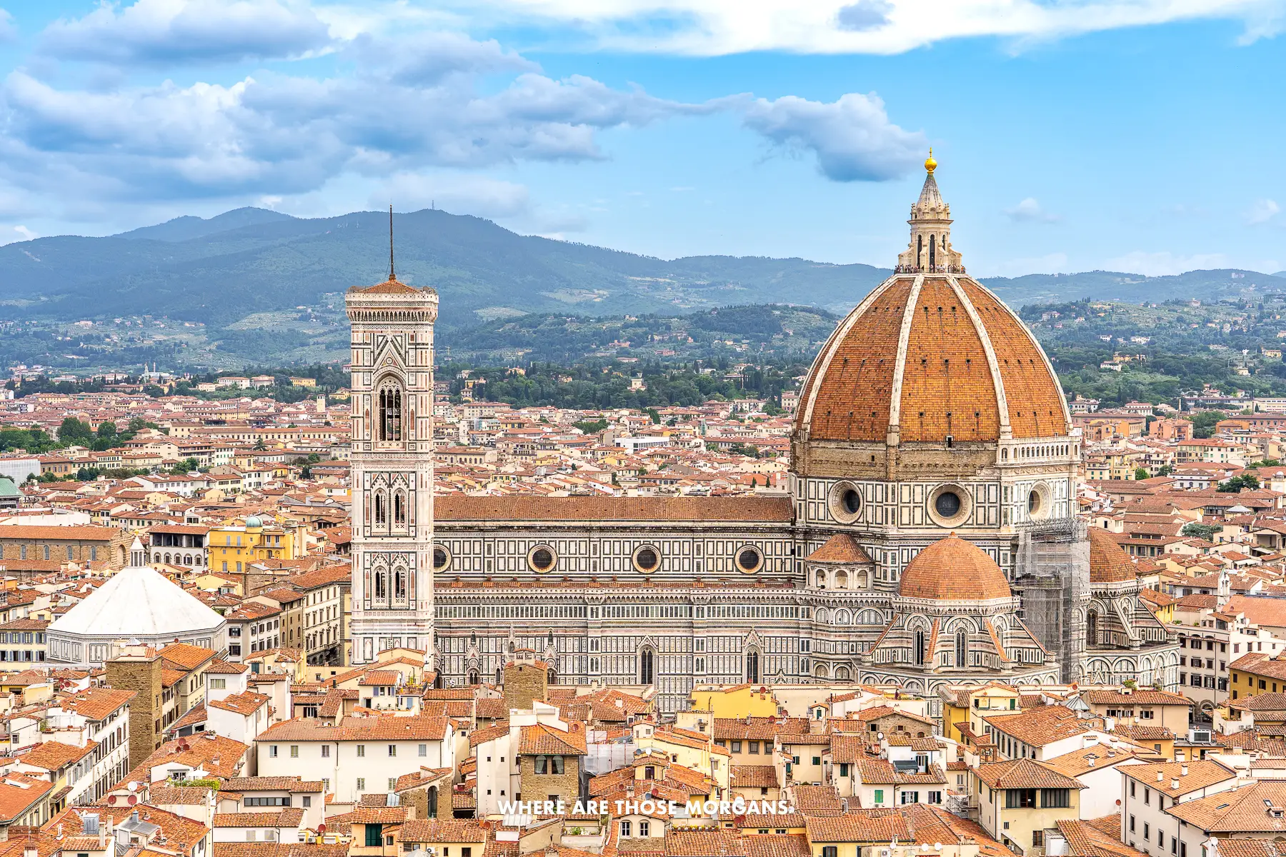 Photo of Florence Duomo surrounded by the city's famous red tiled buildings taken from the top of Palazzo Vecchio for an elevated look over the cathedral