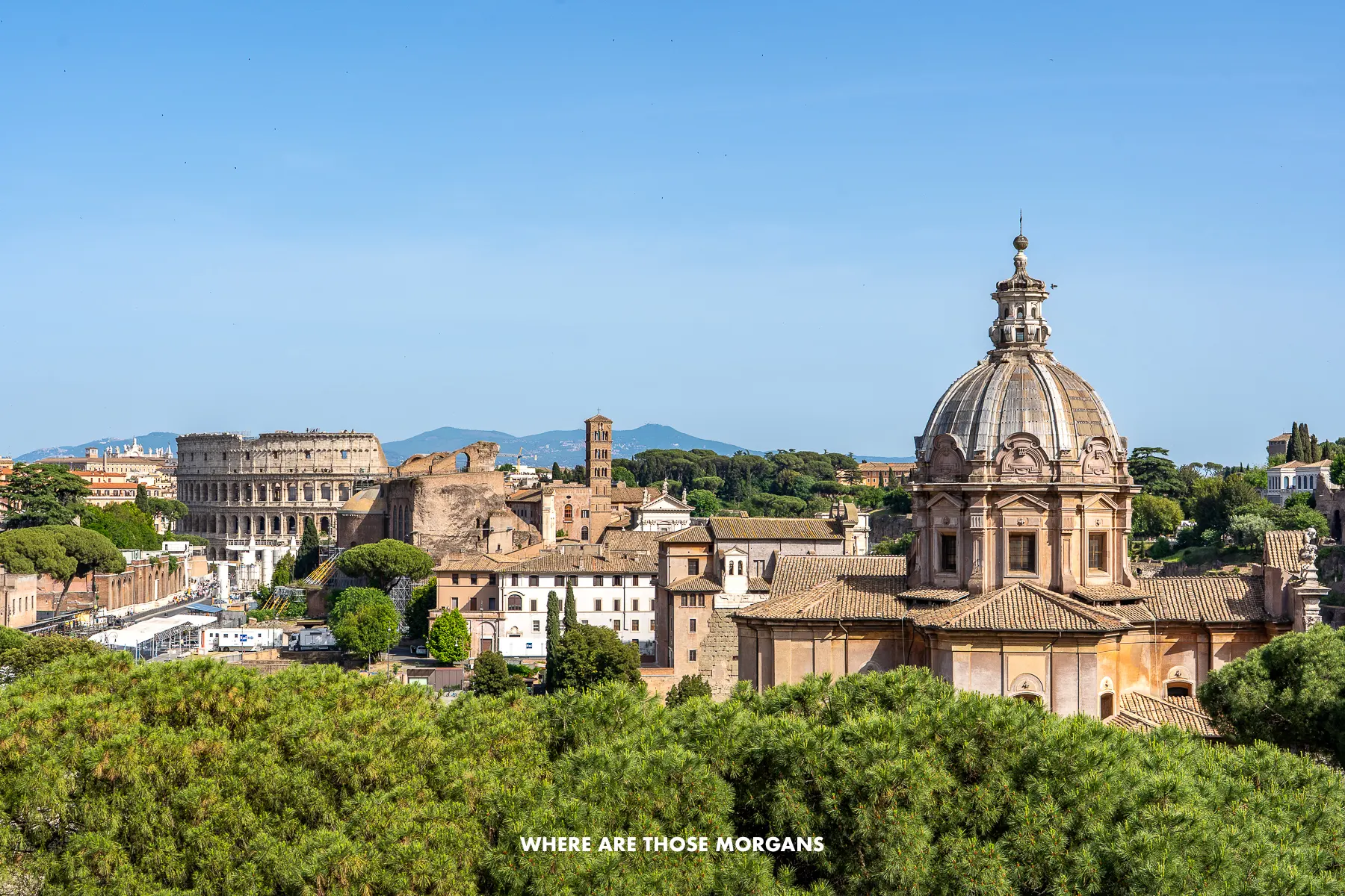 View of the Colosseum and other buildings in Rome above trees from the monument to Victor Emmanuel II
