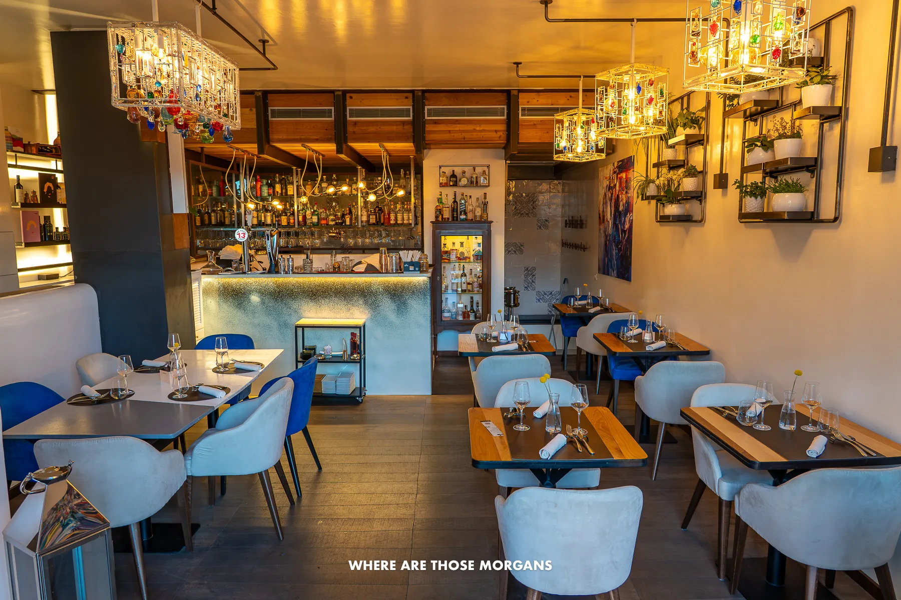 Photo of the inside of a restaurant on the Amalfi Coast called Ohima with no people, tables and chairs, orange mood lighting and a small bar