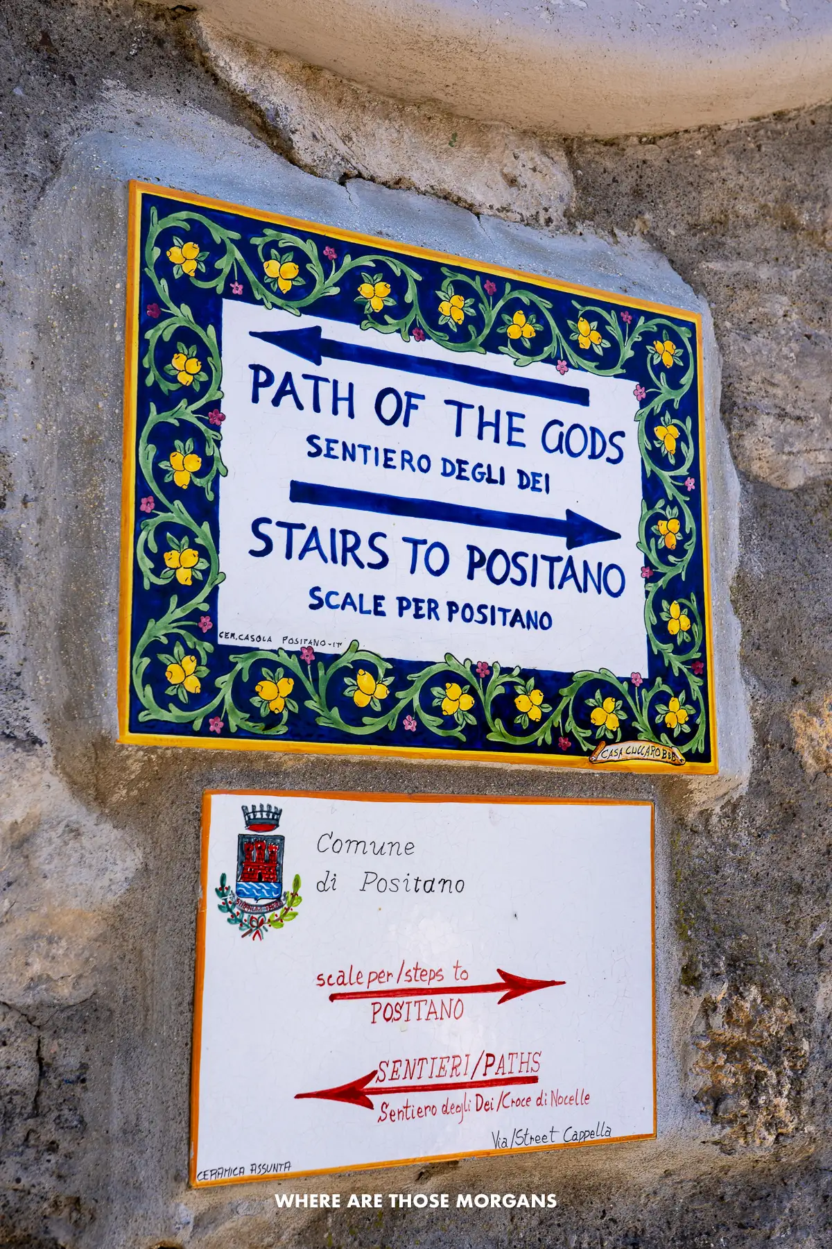 Photo of tiles on a wall with artwork showing steps to Positano and directions to Path of the Gods