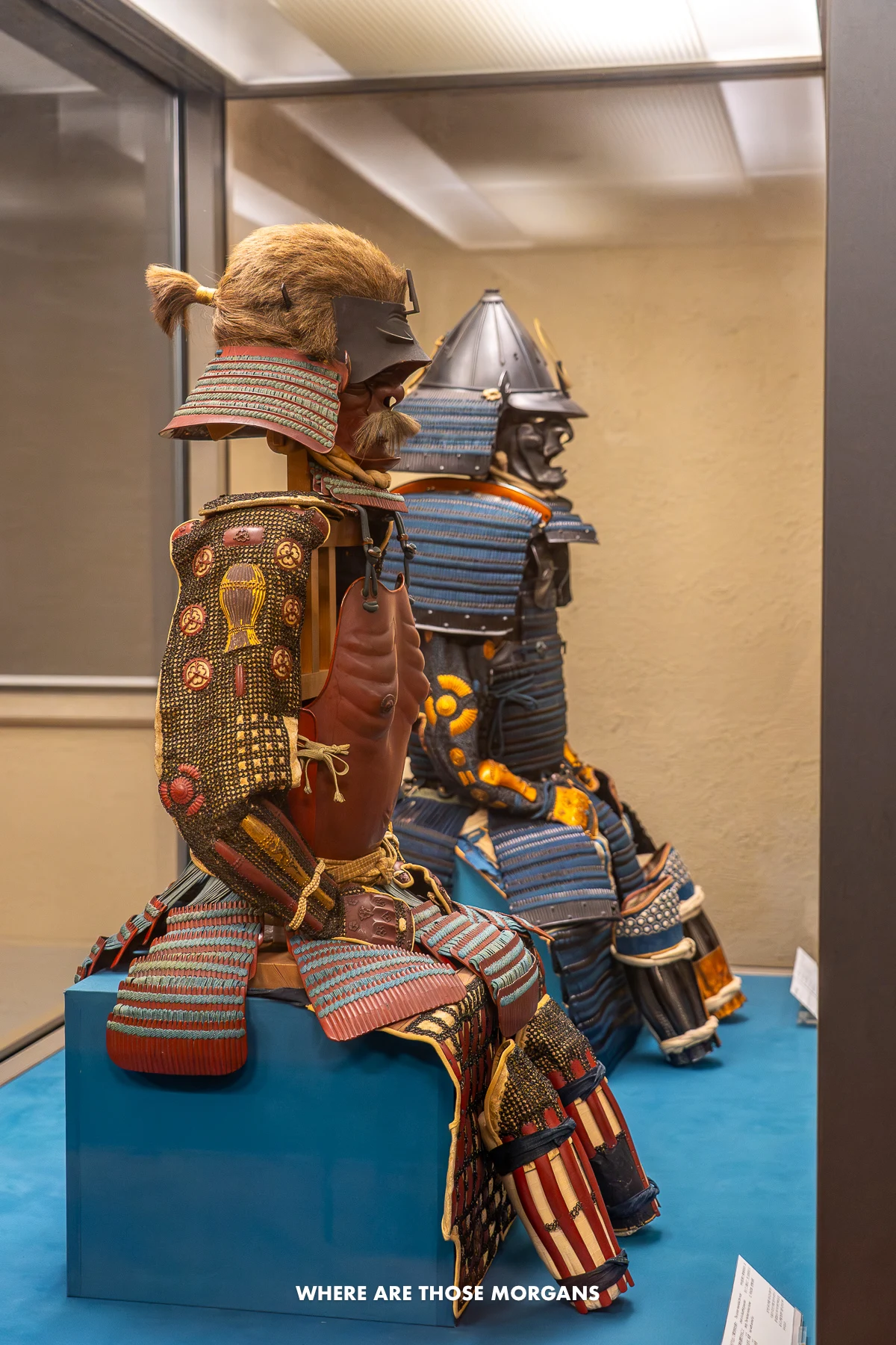 Two samurai armor suits sat on display inside a museum