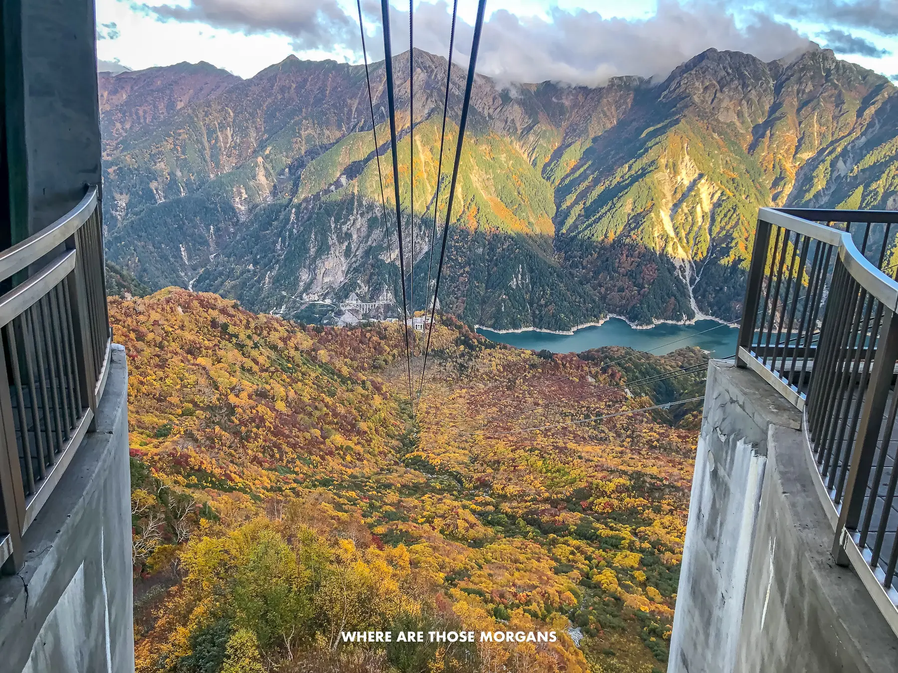 View looking down through mountains from the beginning of a ropeway during the fall foliage season in the Japanese Alps