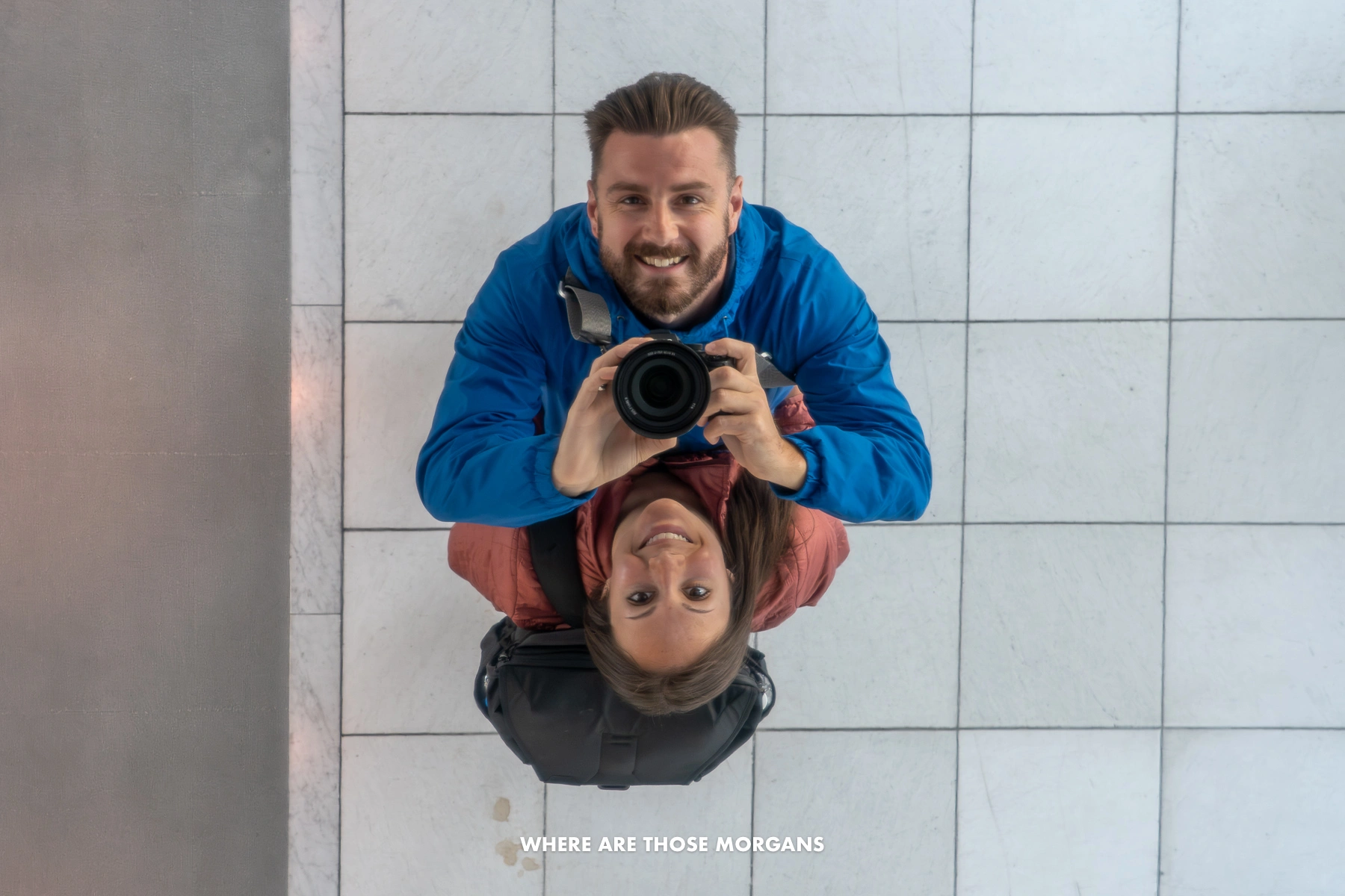Mark and Kristen from Where Are Those Morgans taking a photo looking up in a mirror reflection on the ceiling of an observation deck in Osaka, Japan