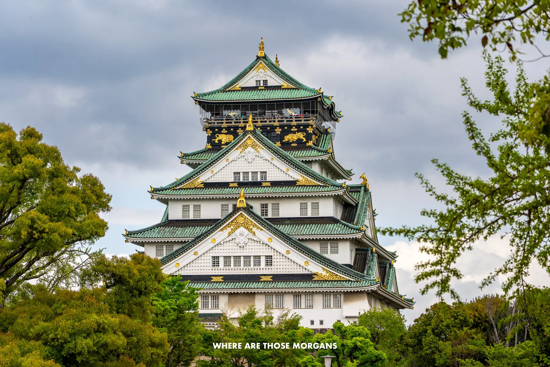 Middle distance view of Osaka Castle with trees below and to the sides on a cloudy day in Japan
