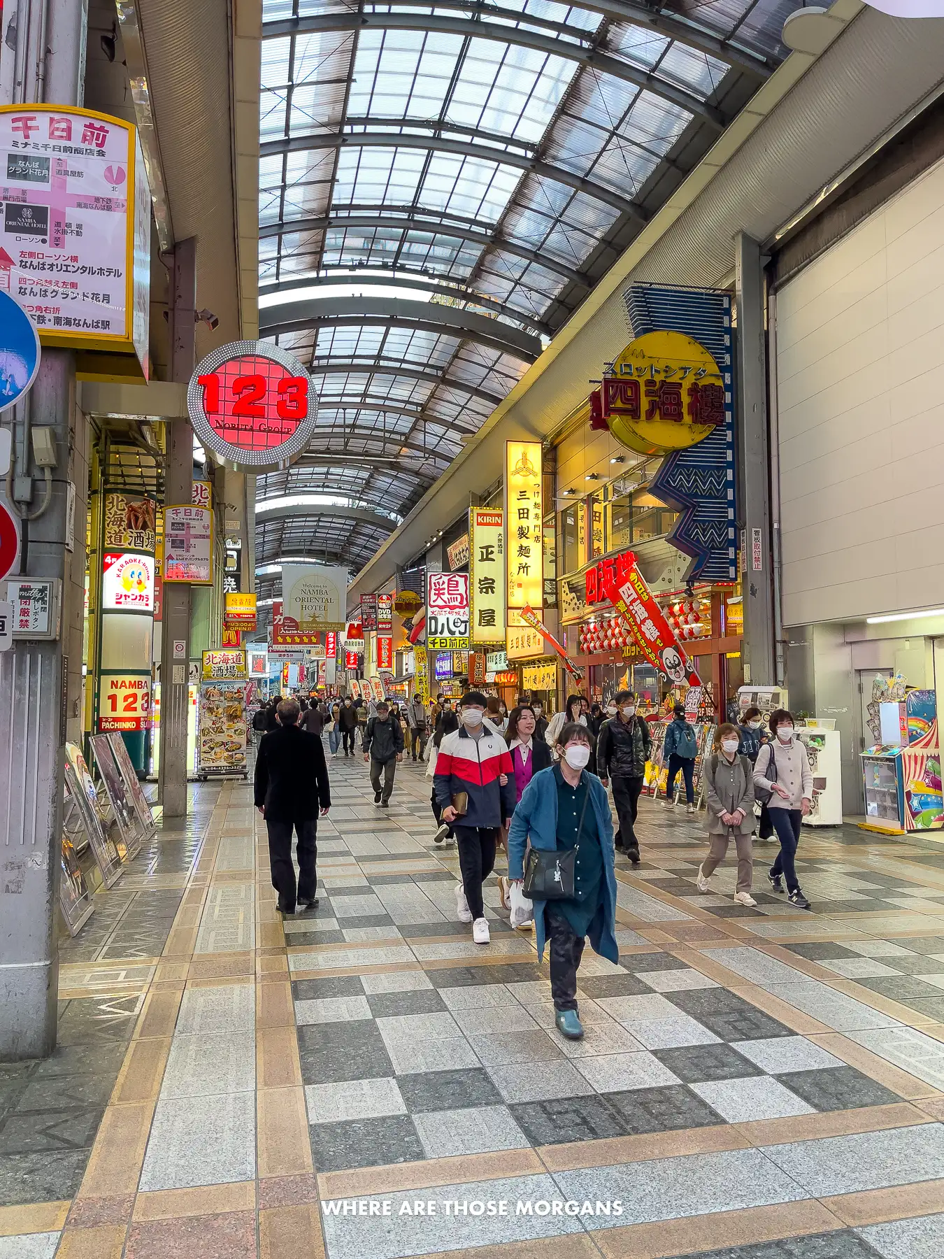 People walking through a wide open covered shopping arcade in Osaka