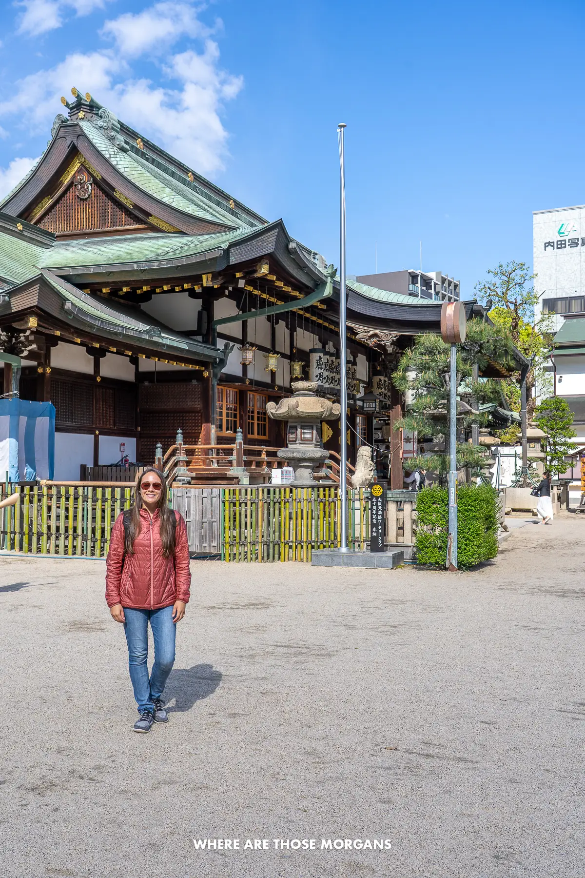 Kristen from Where Are Those Morgans standing in front of a small shrine in Osaka on a sunny day