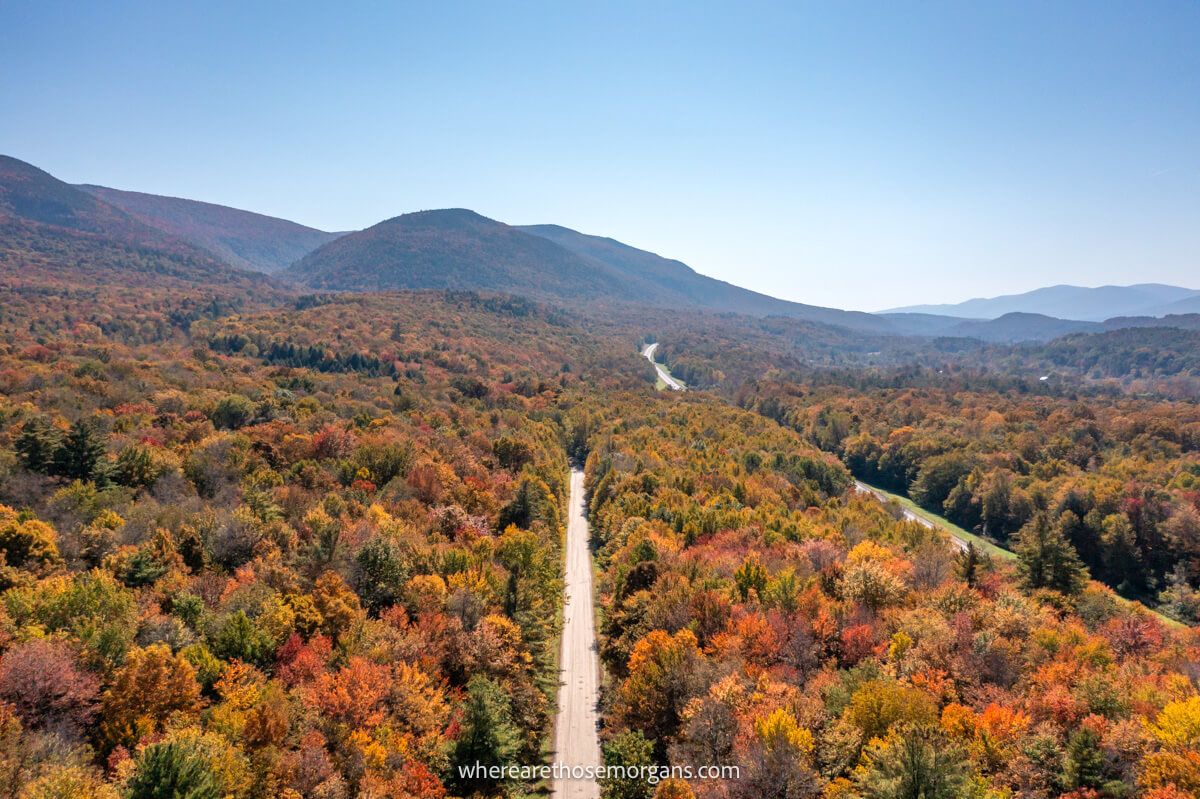 Long stretch of road filled with colorful trees in New England