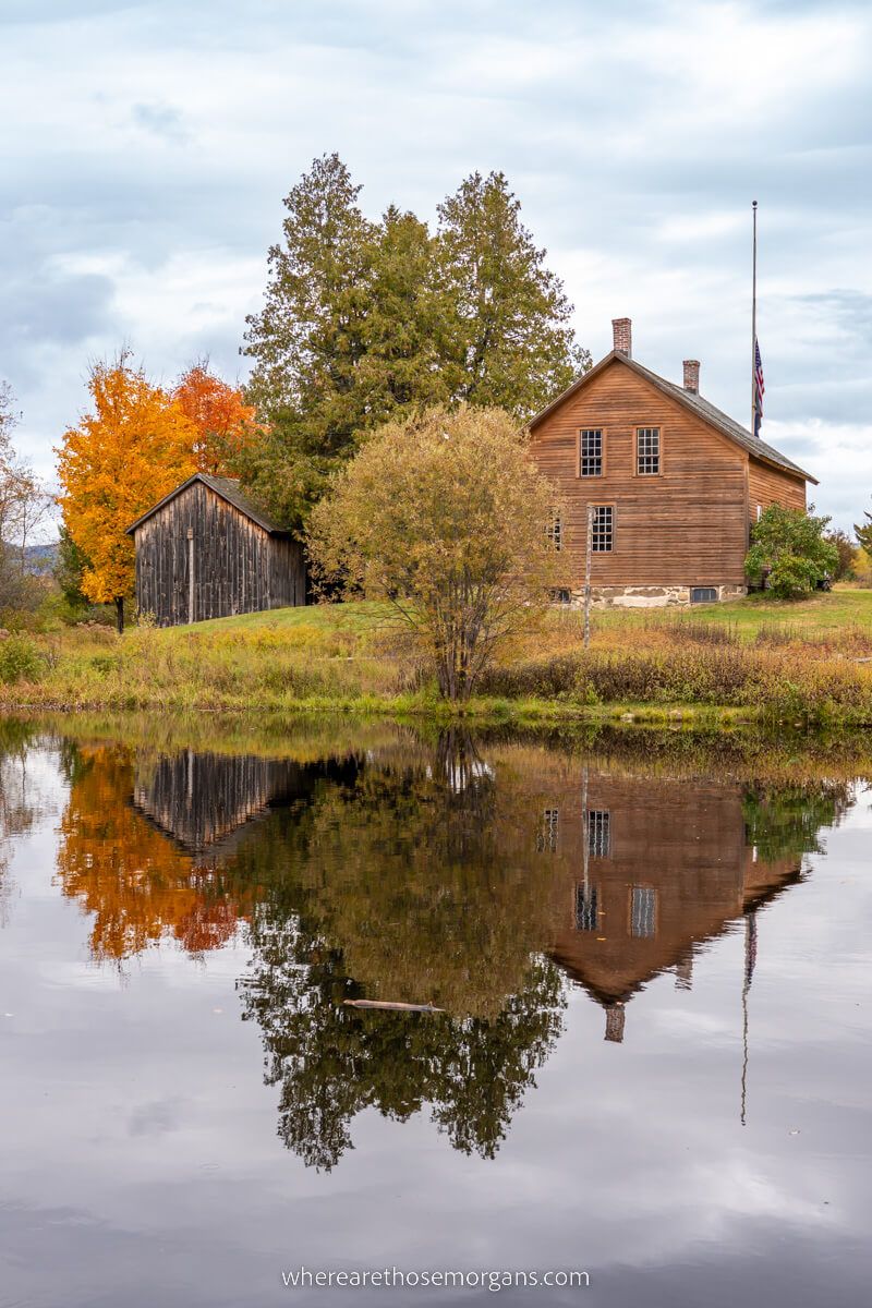 John Brown Farm State Historic Site barn and colorful trees reflecting in water