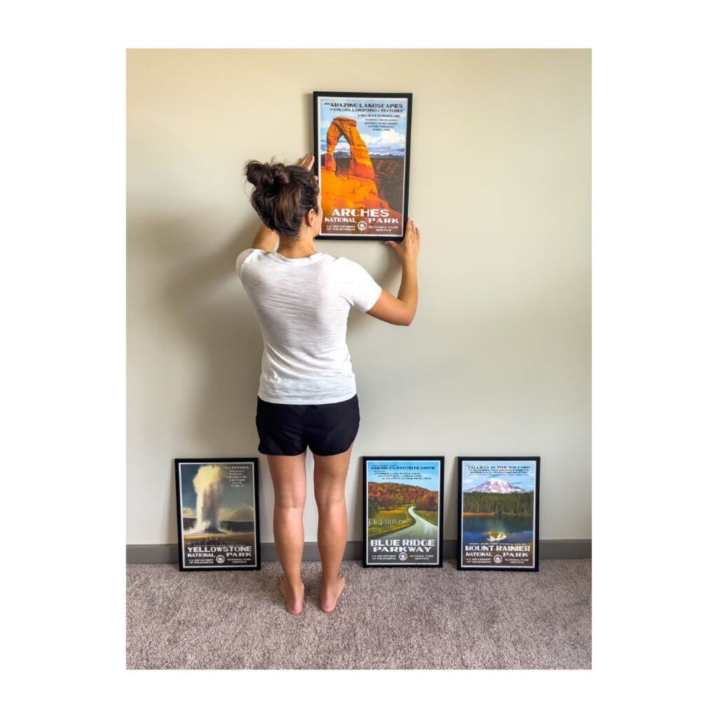 Woman hanging up a few national park posters on the wall