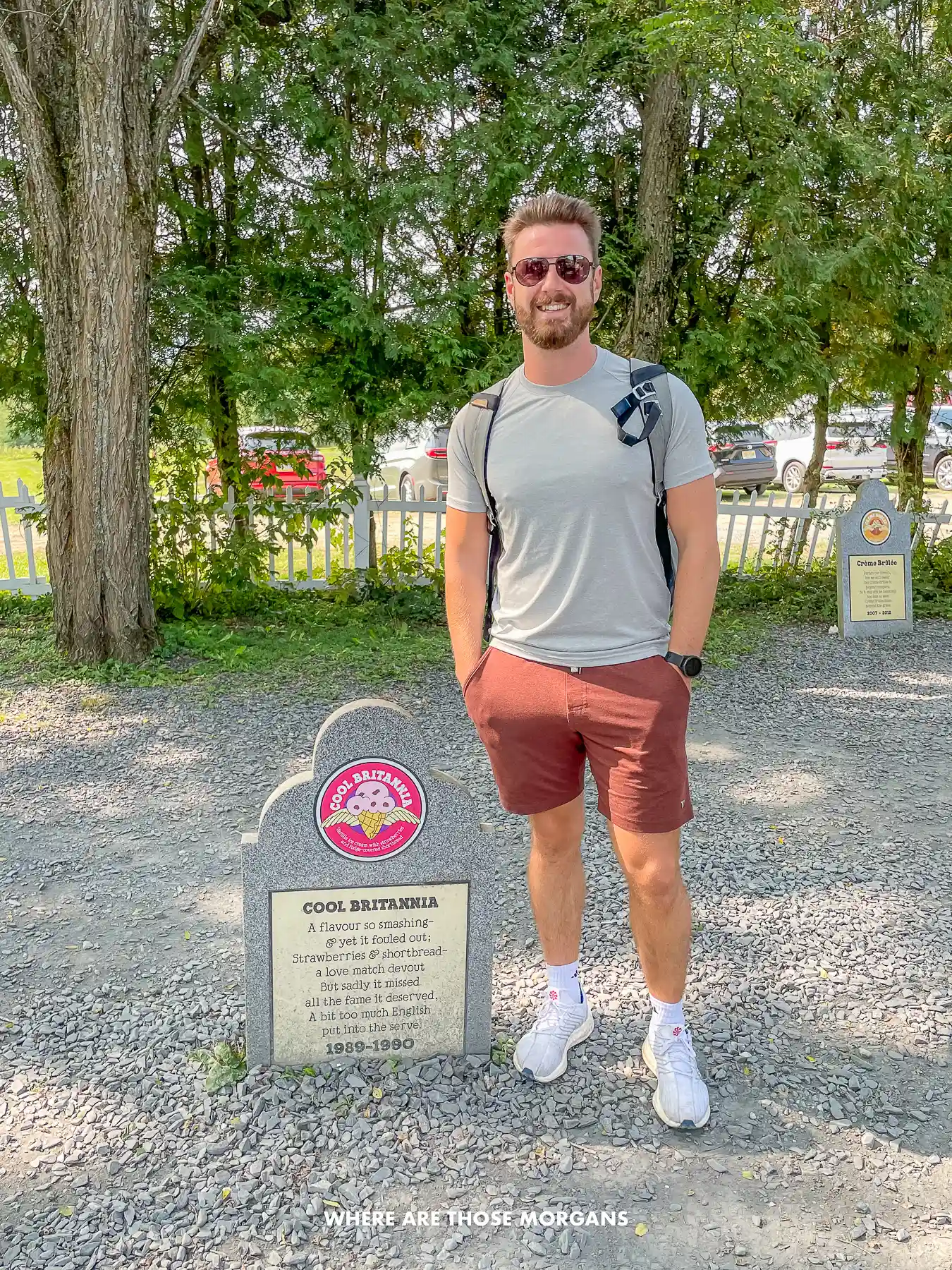 Photo of a tourist standing next to a Ben and Jerry's headstone called Cool Brittania in the flavor graveyard