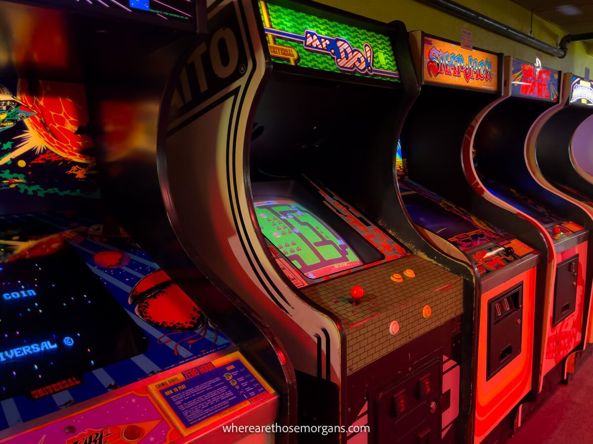Line of old arcade games covered in dim red light