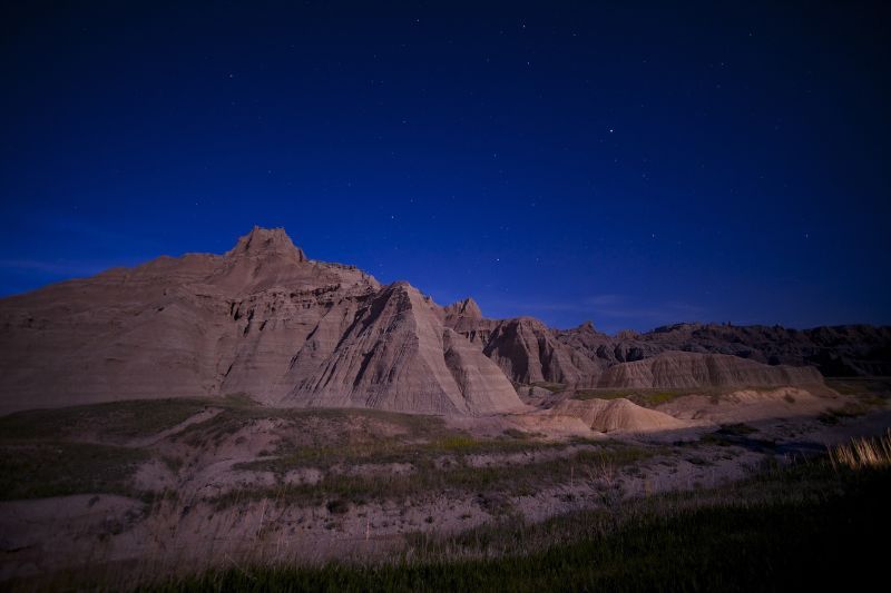 Photo of a rocky landscape taken at night with a smooth deep blue sky