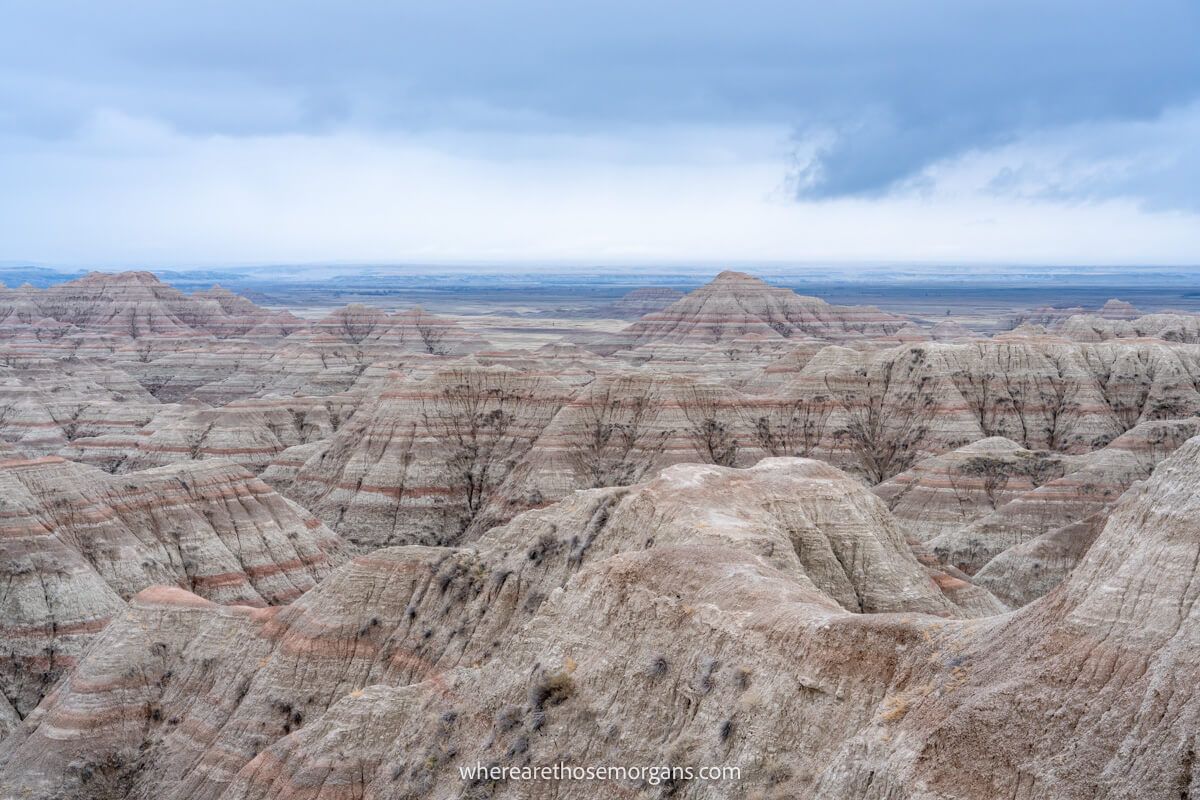 Buttes and canyons with red rock layers under a dark cloudy sky