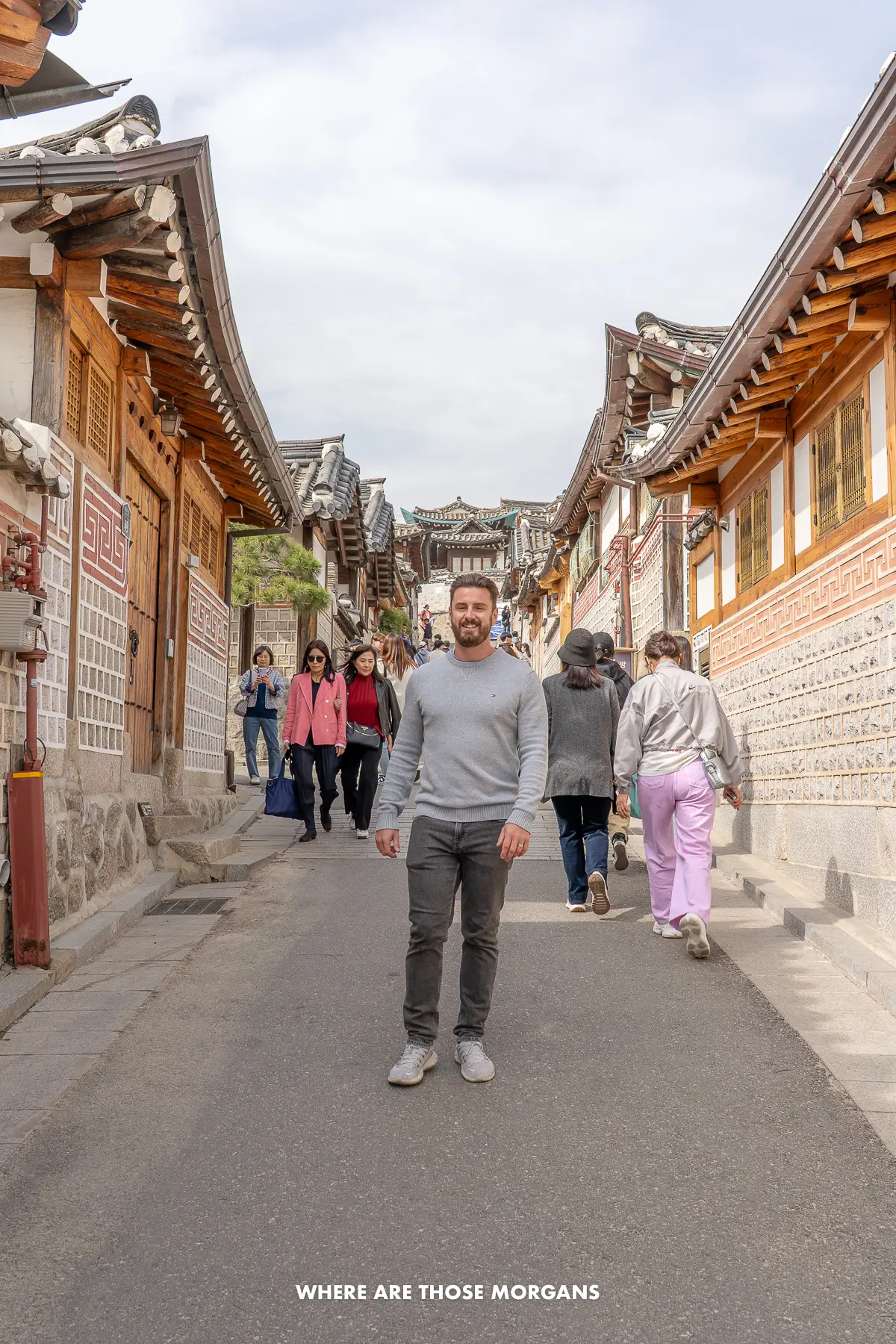 Mark from Where Are Those Morgans walking down a narrow street in old world Seoul