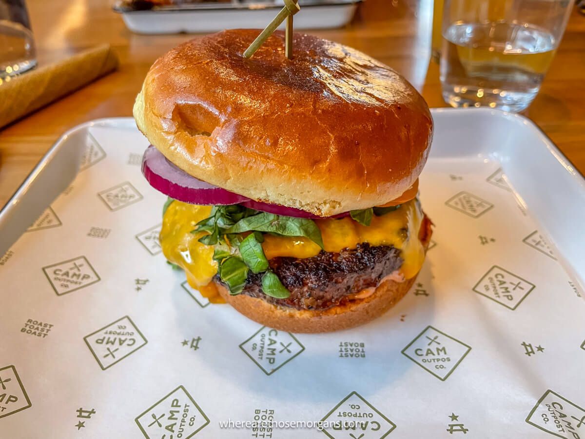 Close up photo of a beef burger in a bread roll on a tray with paper