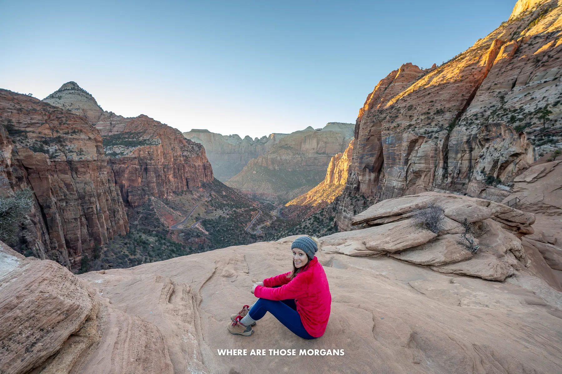 Kristen from Where Are Those Morgans sat near the edge of Canyon Overlook summit at sunset in Zion National Park