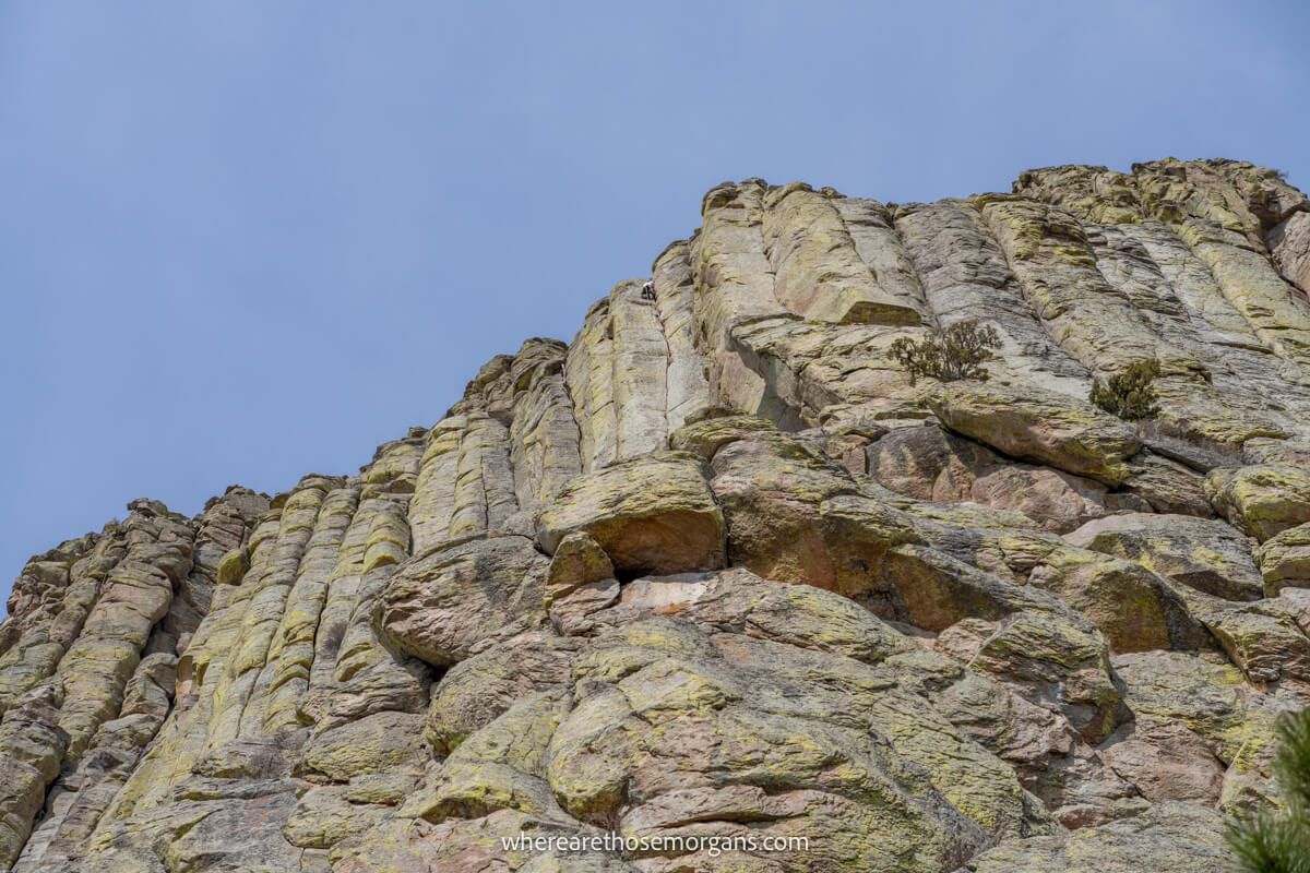 Photo of a climber near the top of a tall rock formation