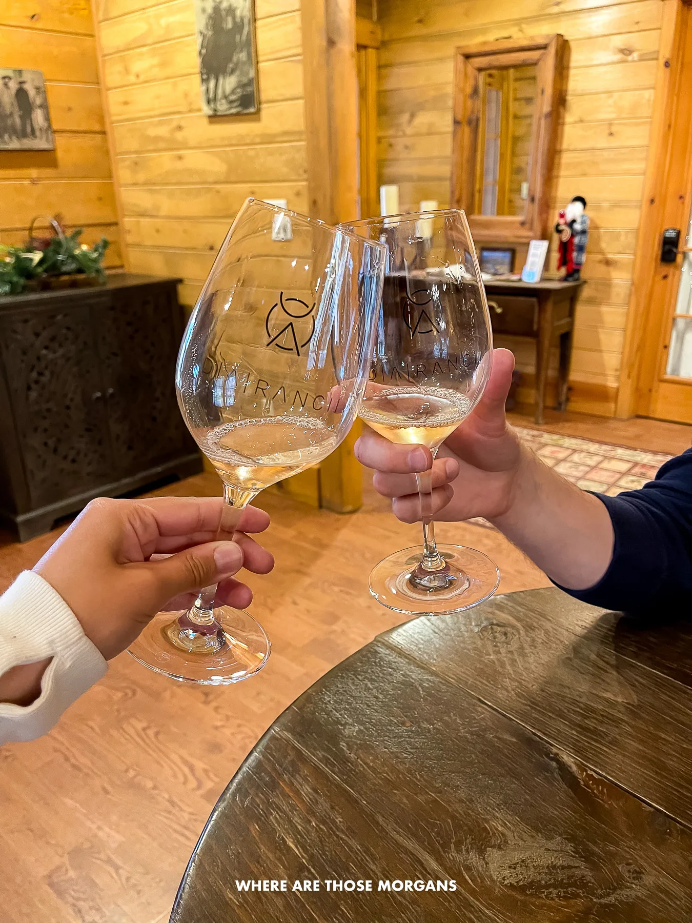 Two glasses of wine clinking inside a wooden winery in Page Springs AZ