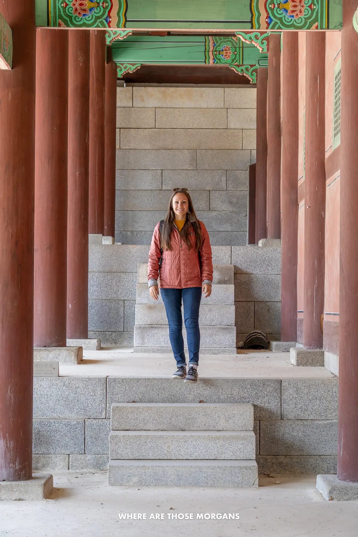 Kristen from Where Are Those Morgans walking between red columns inside Korean palace grounds
