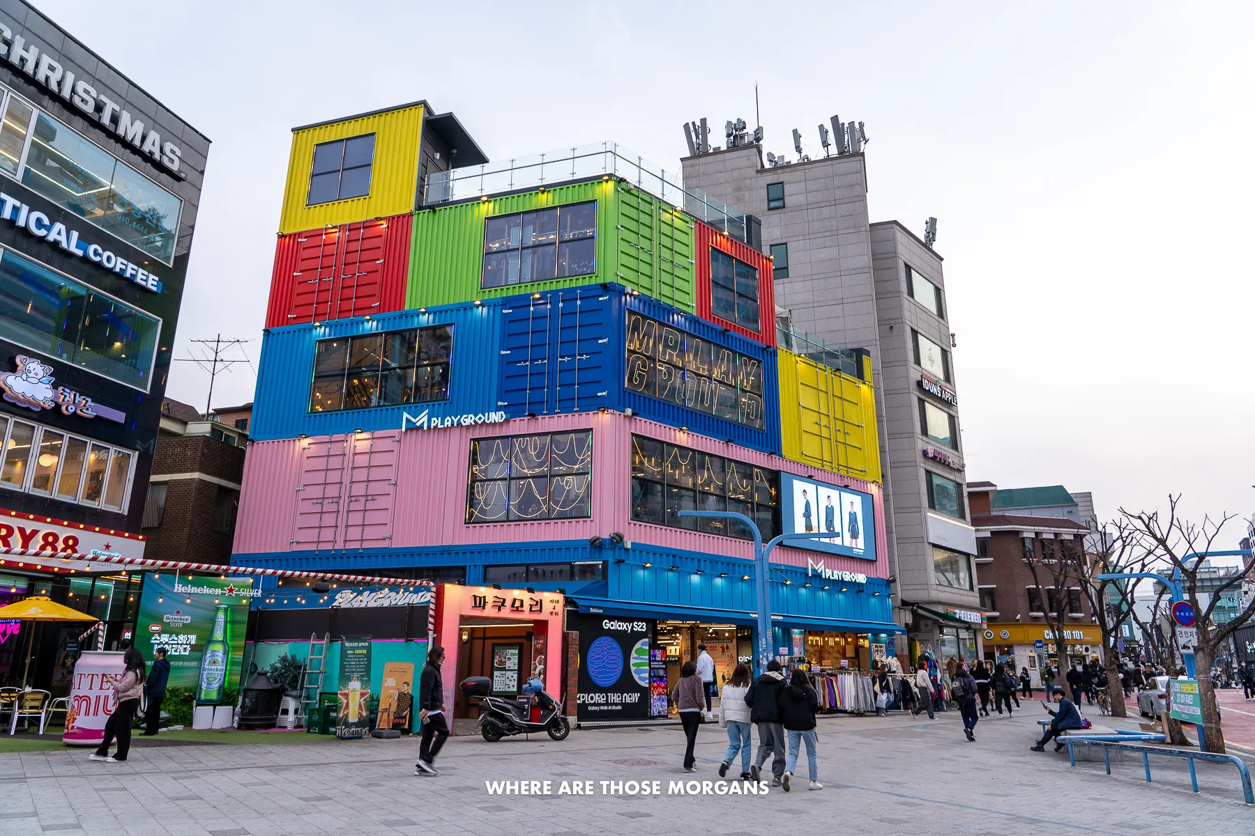 Colorful building exterior with people walking down a shopping street in Hongdae
