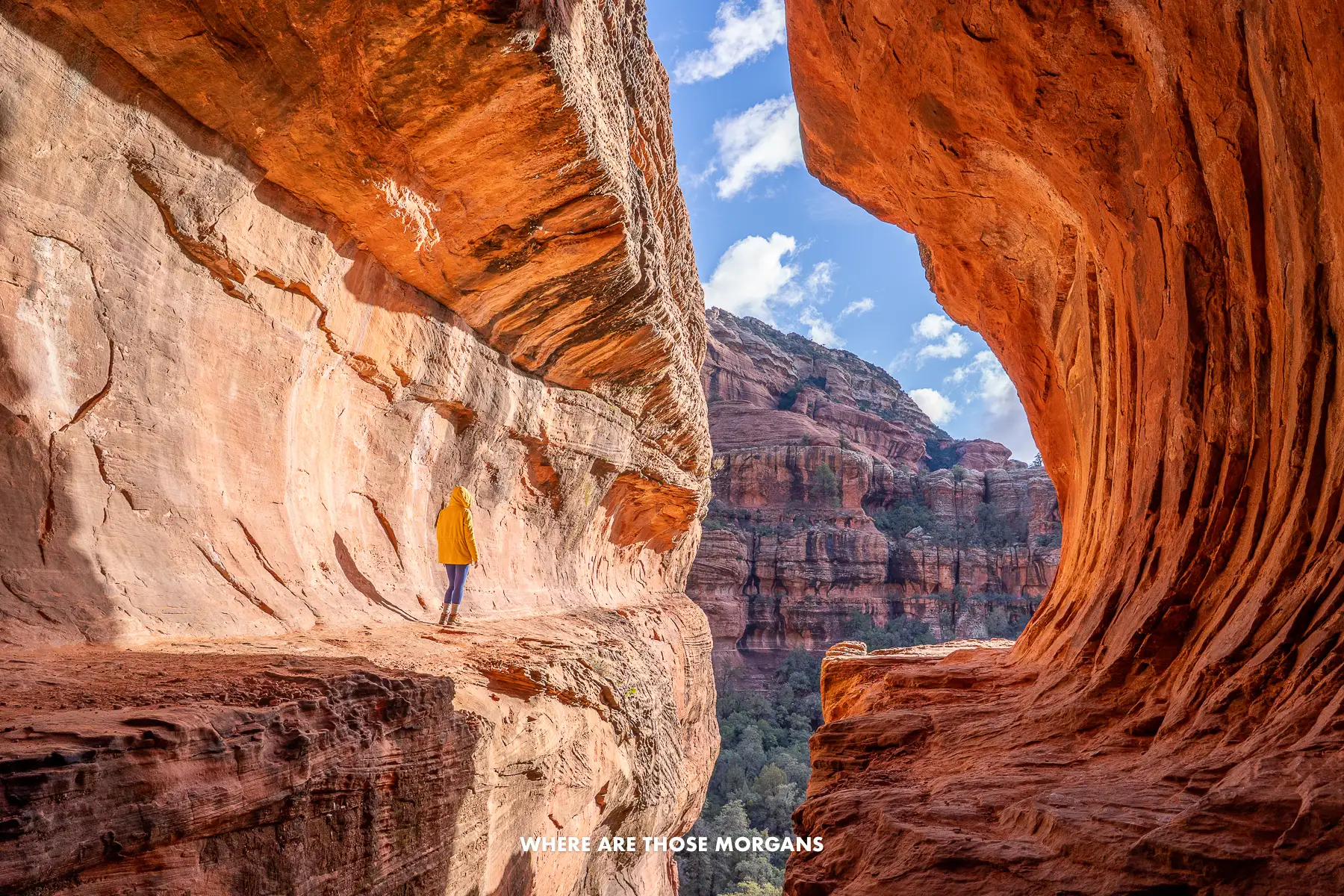 Kristen from Where Are Those Morgans standing alone inside Sedona's Subway Cave with a yellow coat 
