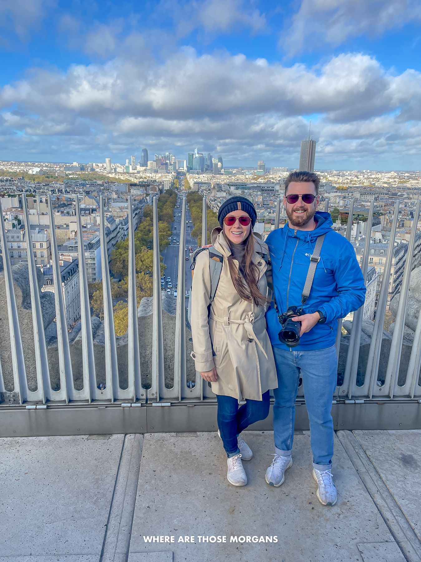 Photo of Mark and Kristen Morgan from Where Are Those Morgans together at the top of the Arc de Triomphe in Paris with views of the city behind