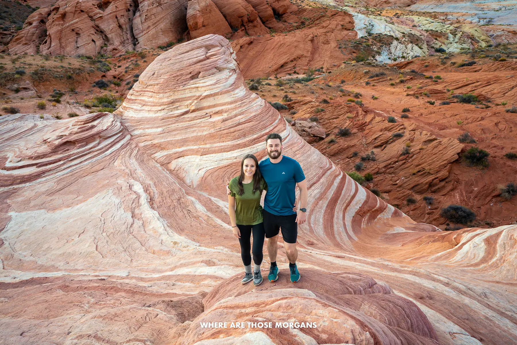 Mark and Kristen from Where Are Those Morgans standing together on a red and white swirling rocky landscape near Las Vegas