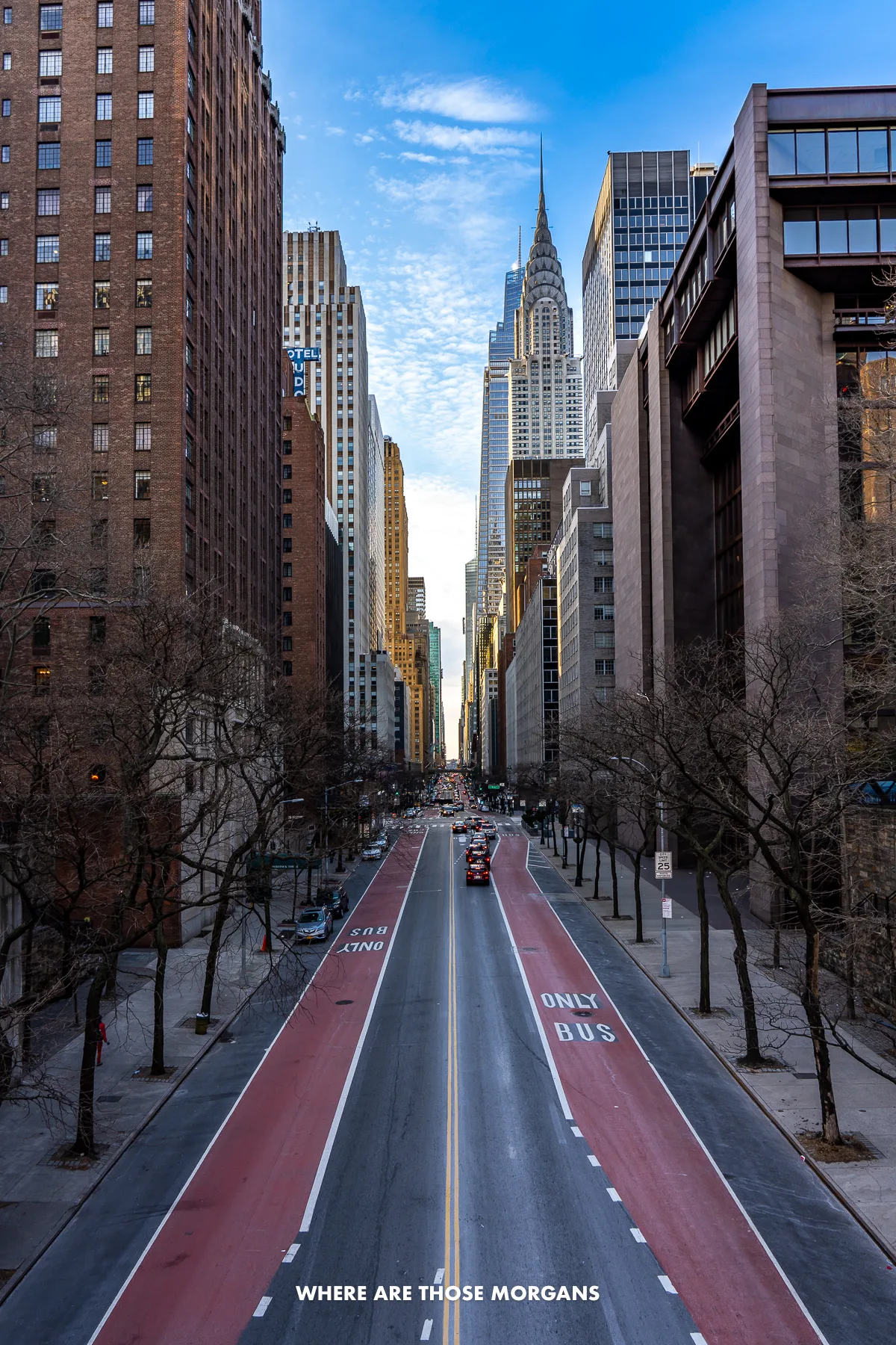 View looking straight down one of New York City's grid streets with barely any traffic on the road