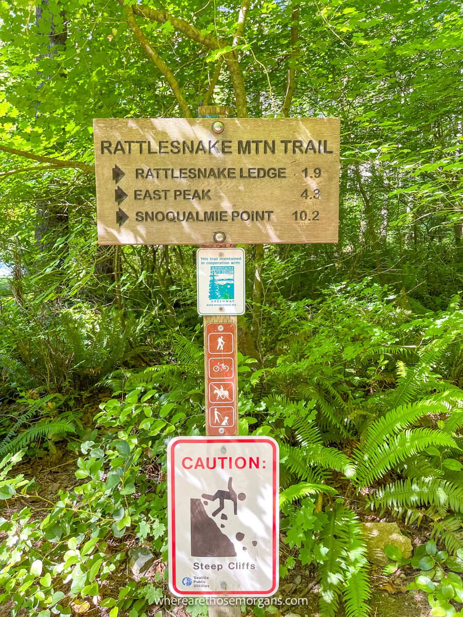 Rattlesnake Ledge Trailhead wooden distance sign with trees behind