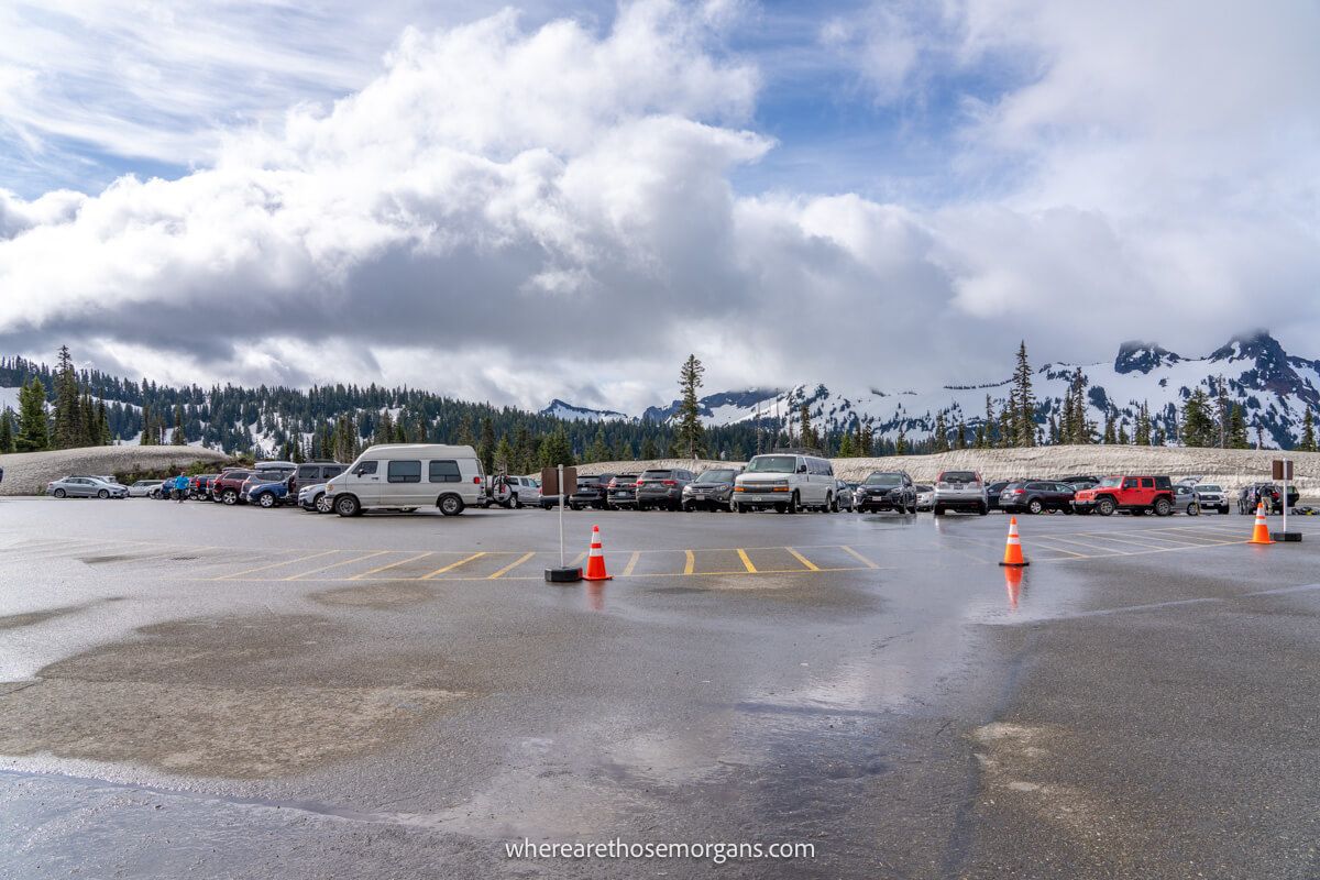 Photo of the parking lot at Paradise in Mt Rainier with lots of cars parked under heavy clouds in the sky at Skyline Trail Trailhead