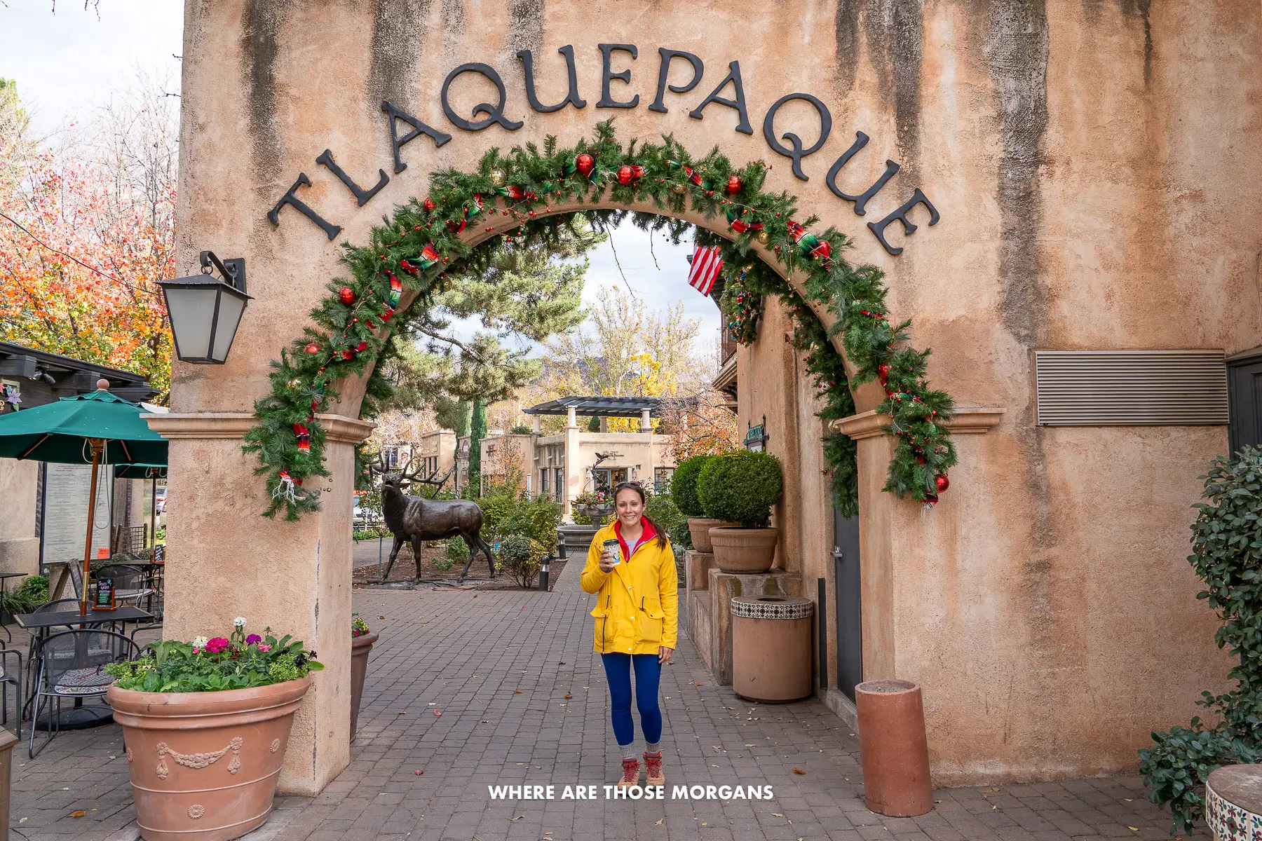 Photo of Kristen from Where Are Those Morgans with a coffee at the entrance to Tlaquepaque Village in Sedona