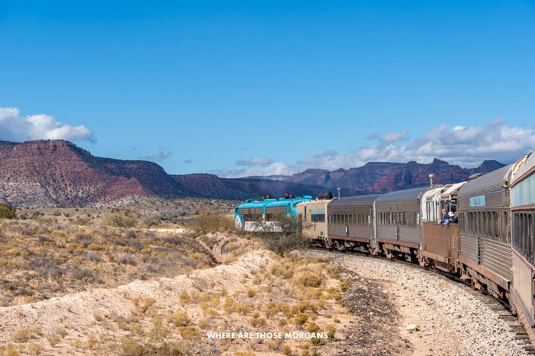Train curving through the Arizona desert under a blue sky